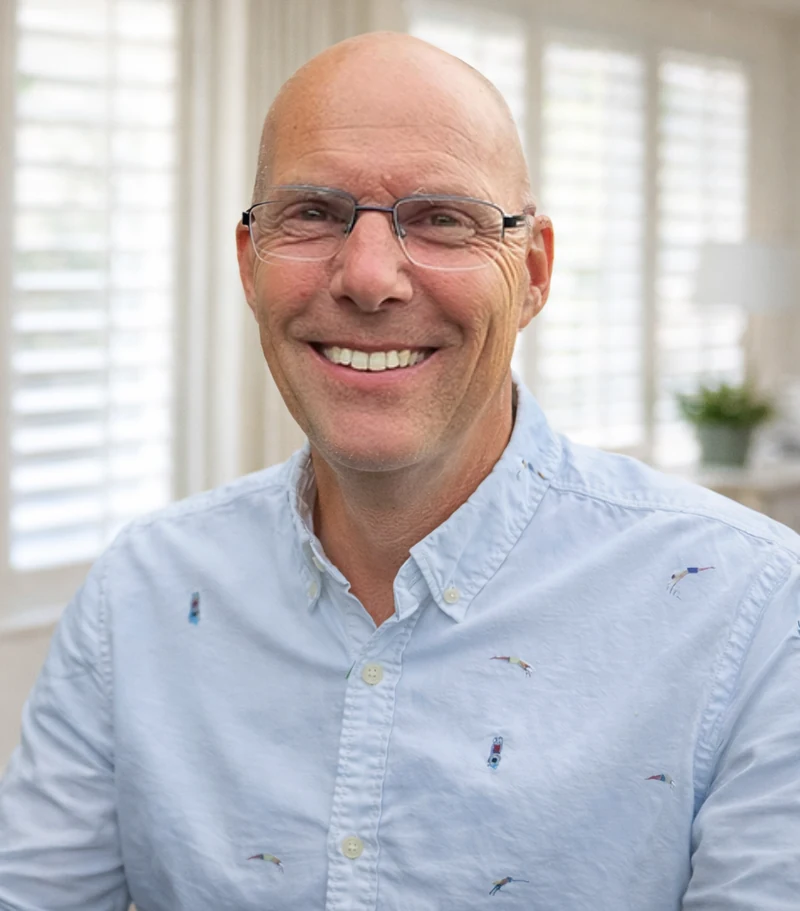 Tom Lassing, lachend achter zijn bureau